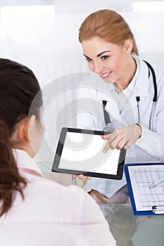 Doctor Showing Digital Tablet To Patient