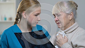 Doctor showing elderly female brain tumor x-ray, bad news, incurable disease