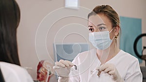 Doctor showing hearing aid to female patient