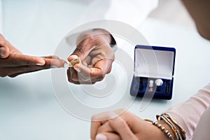 Doctor Showing Hearing Aid To Patient