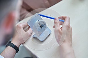 Doctor showing hearing aid to patient