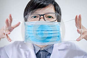 Doctor showing how to wear surgical mask