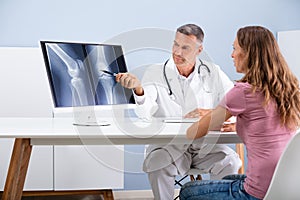 Doctor Showing Knee X-ray To Patient