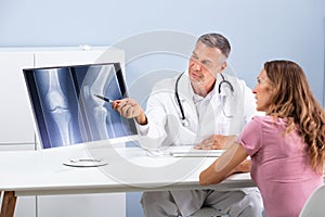 Doctor Showing Knee X-ray To Patient