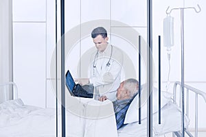 Doctor showing a laptop screen to his patient