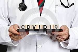 a doctor showing latter blocks spelling covid19