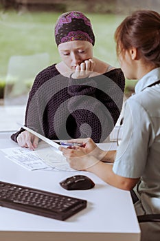 Doctor showing medical records to cancer patient