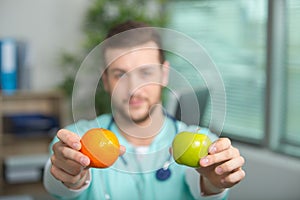 Doctor showing pear and apple