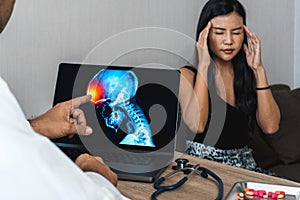 Doctor showing a x-ray of pain in the brain on a laptop. Migraine Headache