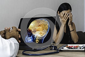 Doctor showing a x-ray of pain in the brain on a laptop. Migraine Headache