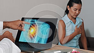 Doctor showing x-ray of pain in the heart on a laptop with woman patient. Heart attack symptoms