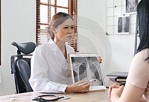 Doctor showing x-ray result to patient in clinic.