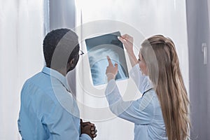 Doctor showing x-ray of shoulder to african american patient in the