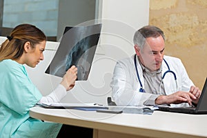 Doctor showing x-ray to colleague in medical office