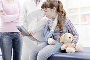 Doctor showing an x-ray to a young patient with broken arm