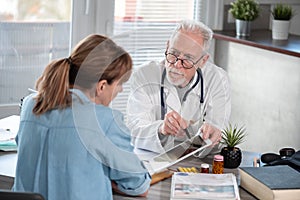 Doctor showing reports on digital tablet to his female patient