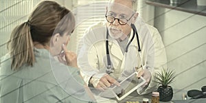 Doctor showing reports on digital tablet to his female patient, geometric pattern