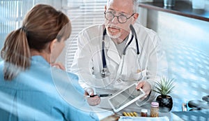 Doctor showing reports on digital tablet to his female patient; light effect