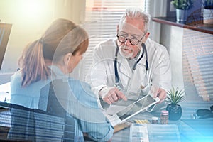 Doctor showing reports on digital tablet to his female patient  multiple exposure