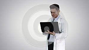 Doctor showing results in laptop on gradient background.