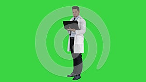 Doctor showing results in laptop on a Green Screen, Chroma Key.