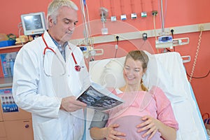 Doctor showing scan results to pregnant lady