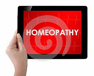 Doctor showing tablet with HOMEOPATHY text.