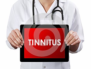 Doctor showing tablet with TINNITUS text. photo