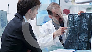 Doctor showing to a patient a detailed X Ray scan