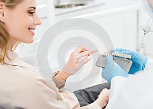 Doctor showing tooth implants to female patient in modern