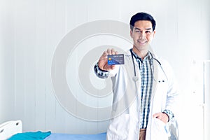 The doctor shows the credit card in his hand To show ideas about paying medical bills by credit card