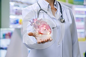 Doctor shows heart in his hand .