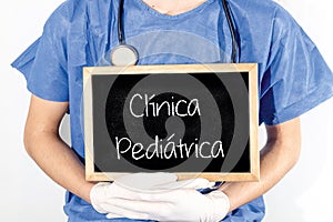 Doctor shows information on blackboard: pediatric clinic in portuguese. Medical concept photo