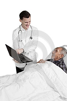 Doctor shows laptop to elderly male patient