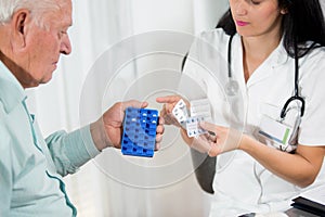 Doctor shows the patient how to use daily dose pills