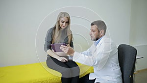 Doctor shows a pregnant woman a snapshot of her baby`s ultrasound