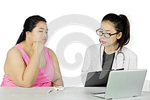 Doctor shows result test to her fat patient on studio