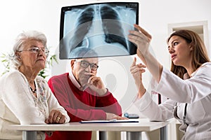 Doctor shows results to old patient x-ray of the lungs