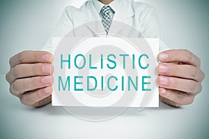 Doctor with a signboard with the text holistic medicine photo