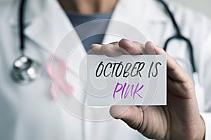 Doctor and signboard with the text october is pink