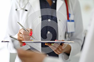 Doctor signs document with ballpoint pen at meeting with colleague in clinic closeup