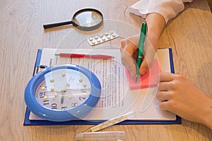 Doctor sits in a medical office in the clinic and writes medical history. Healthcare and medical concept. doctor`s working table