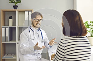 Doctor sitting at his desk and having discussion with patient who came to hospital