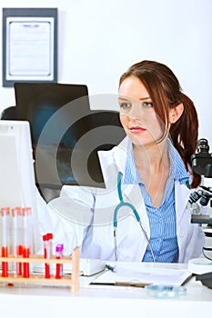 Doctor sitting at table and analyzing roentgen