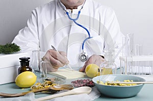 Doctor sitting at the table. Many ingredients for alternative medicine.Dried berries,herbs,lemons and diffirent portions of natura