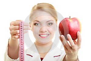 Doctor specialist holding fruit apple and measure tape