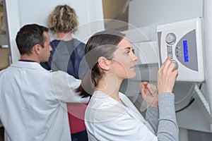 Doctor standing assisting patient undergoing mammogram x-ray tes