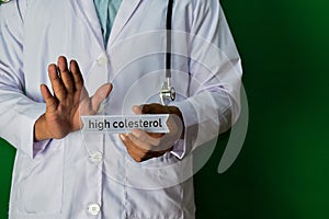 Doctor standing on Green background. Selective focus in hand. High Colesterol paper text. Medical and healthcare concept photo