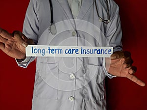 A doctor standing, Hold the long-term care insurance paper text on red background.