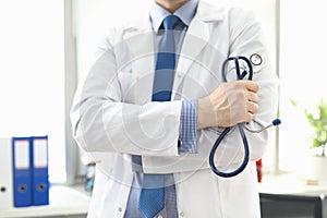 Doctor standing in office with stethoscope in hand